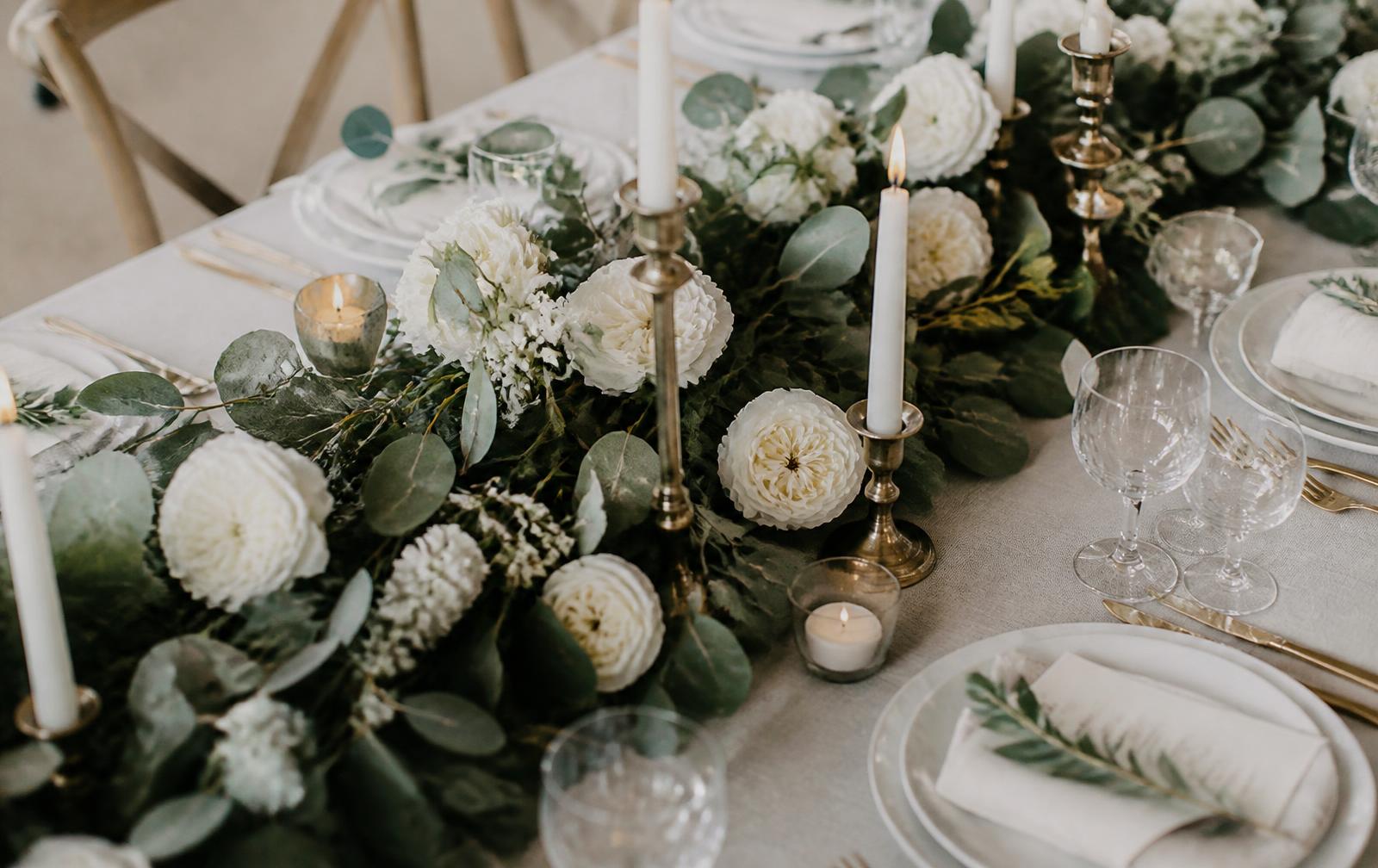 Ivory and evergreen wedding table setting with candlelight